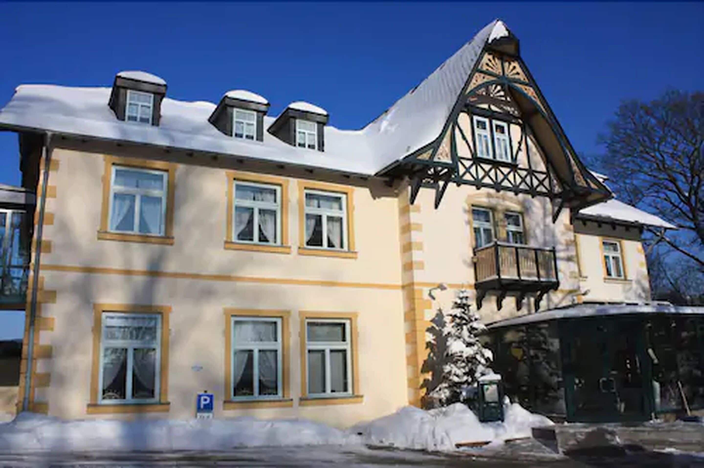 A traditional building with multiple windows and a snow-covered roof.