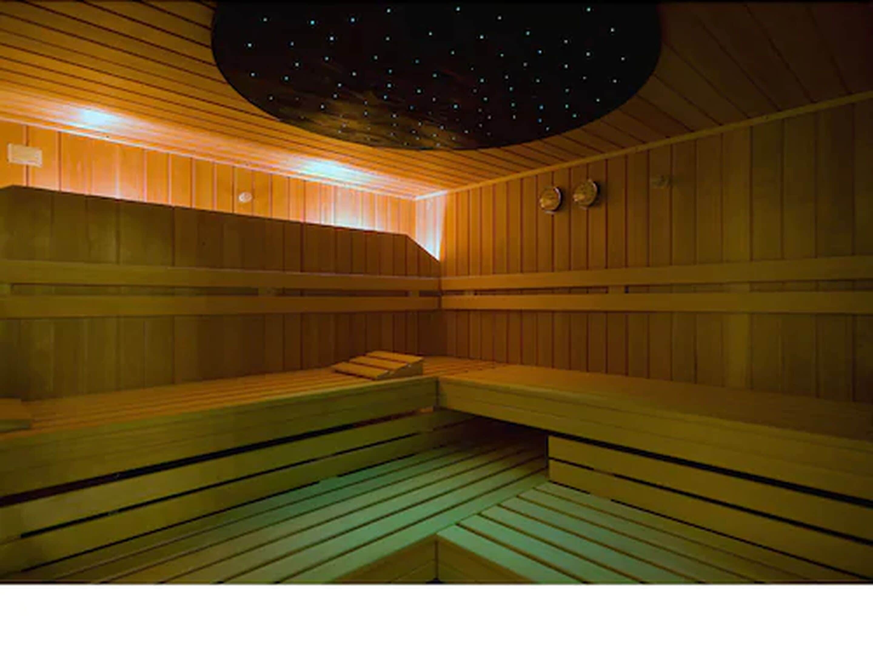 Uma sauna com bancos de madeira e teto estrelado.