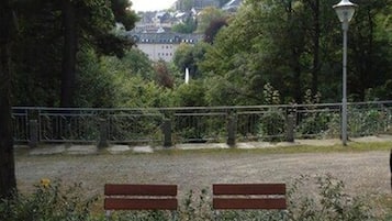An outdoor seating area with a table and chairs, a lamp post, and a view of a building in the background.