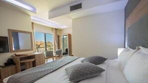 Una habitación de hotel con una cama grande, un escritorio, una silla y un televisor.
