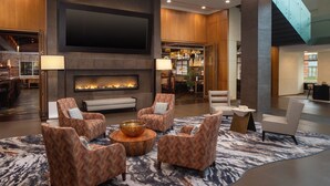 A spacious lobby with a fireplace, comfortable seating, and a staircase. - The Hotel at Arundel Preserve (Hanover)