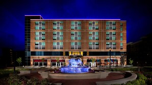 A hotel with a central fountain, a brick facade, and a sign reading "The Hotel". - The Hotel at Arundel Preserve (Hanover)