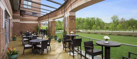 An outdoor patio with brick walls, metal beams, and outdoor furniture.