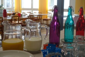 Enjoy meals in this dining area with a table set for a meal, featuring a selection of bottles and snacks.