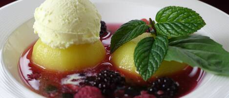 A dessert with ice cream and berries on a white plate.