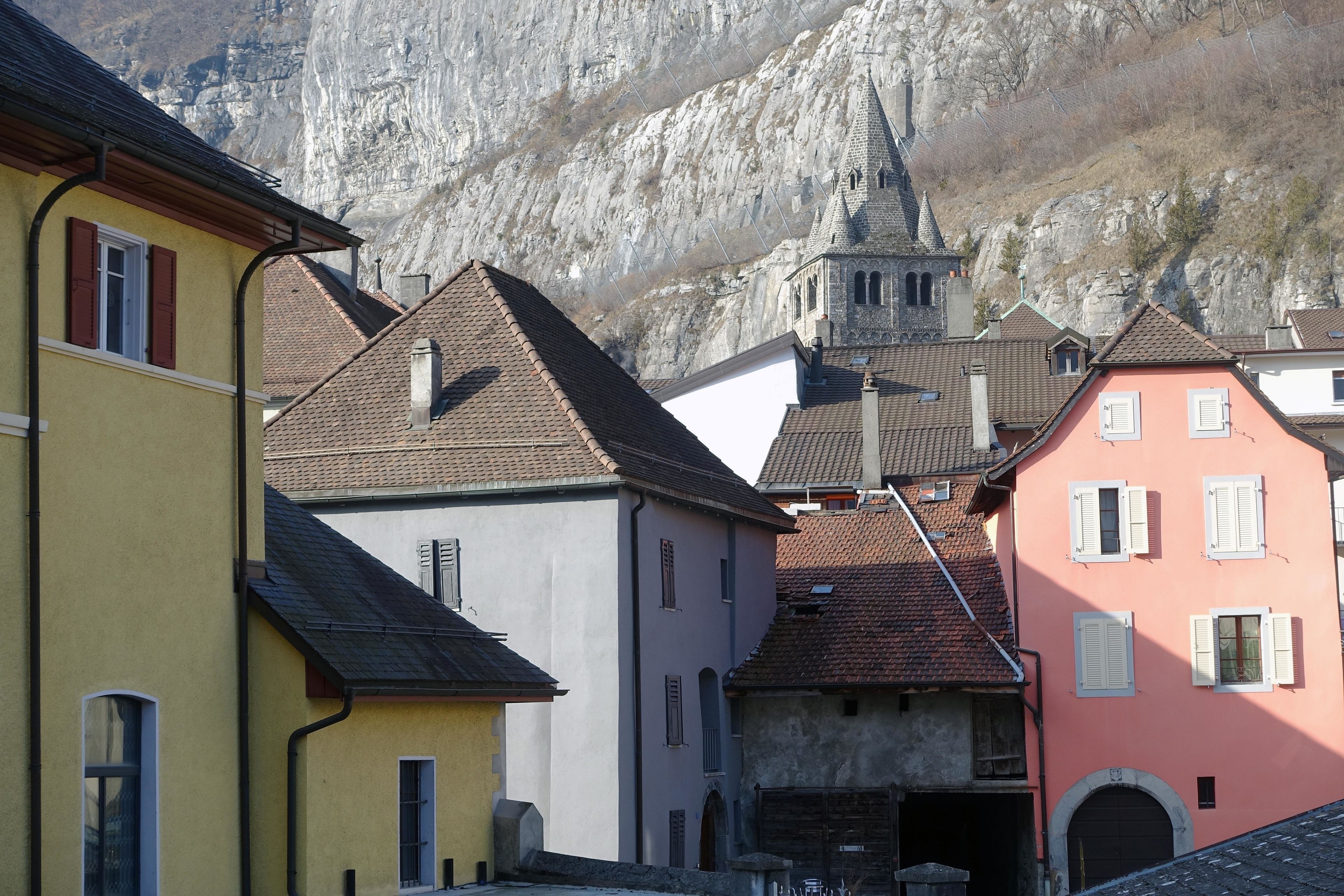 A row of colorful buildings with a church in the background.