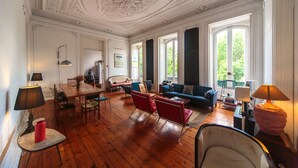 A spacious living room with a wooden floor, a dining area, and a sofa set. - Independente Príncipe Real (Lisbon)