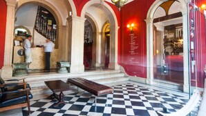 A lobby with checkered flooring, a bench, and a staircase leading to an upper level. - Independente Príncipe Real (Lisbon)