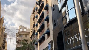 Un hotel con balcones, un reloj y un letrero que dice "Hotel Atlantico Centro".