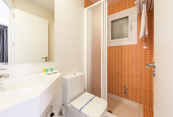 A bathroom with a white sink, toilet, and shower area. - Apartamentos Flats Friends Atlantida (Benidorm)