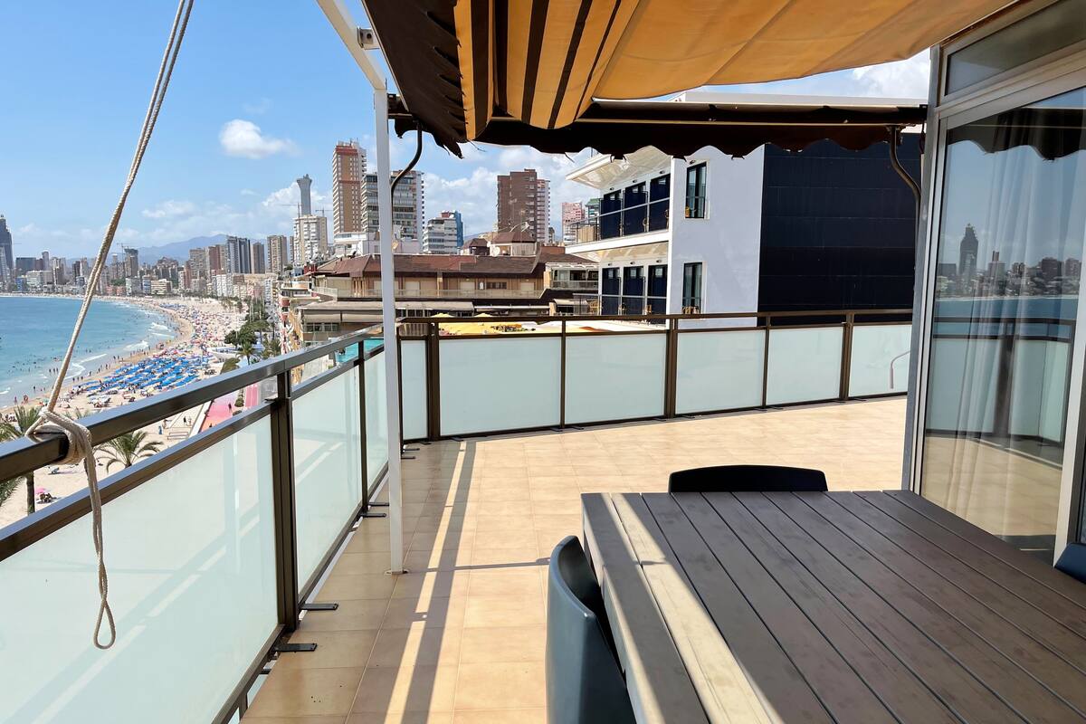 A balcony with a view of a beach and cityscape.