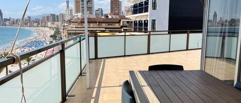 A balcony with a view of a beach and cityscape.