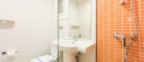 Un baño con inodoro, lavabo y ducha.