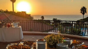 A buffet table with various food items and a sunset view over the ocean. - Villaggio La Pizzuta (Parghelia)