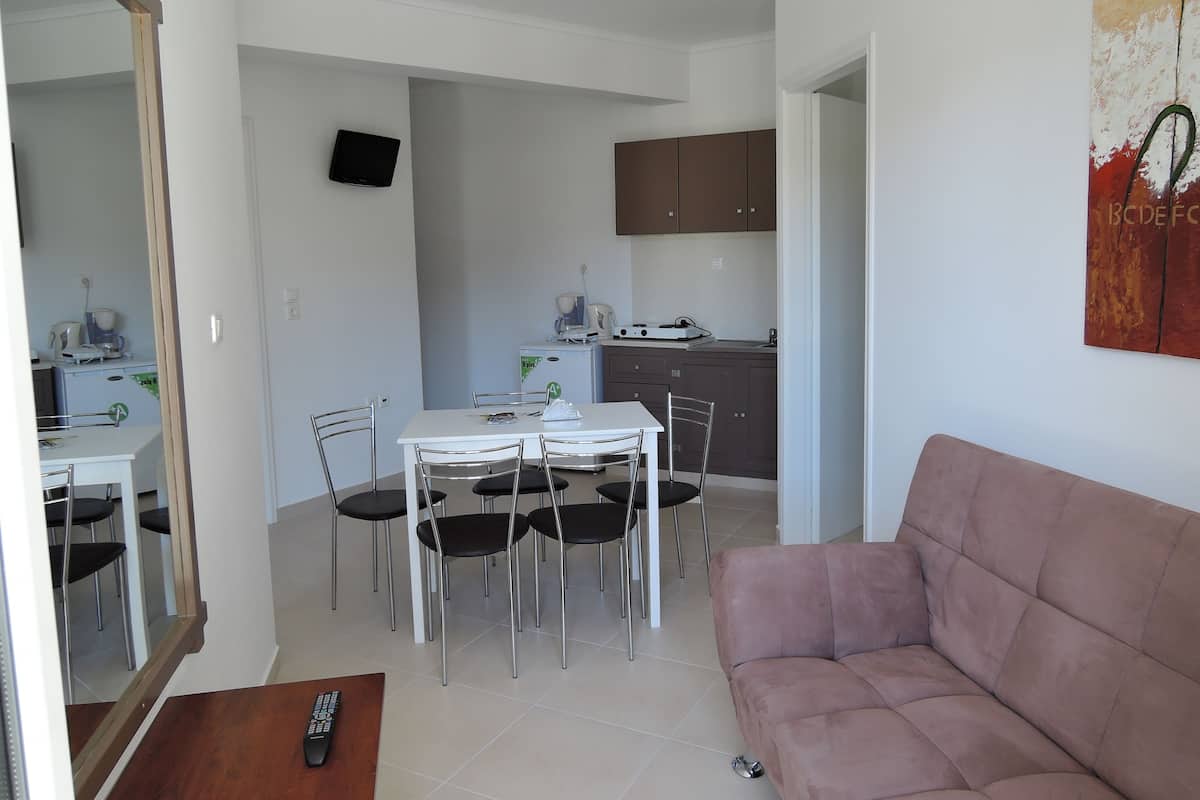 Un espace de vie compact comprenant un coin repas, une kitchenette et un canapé.