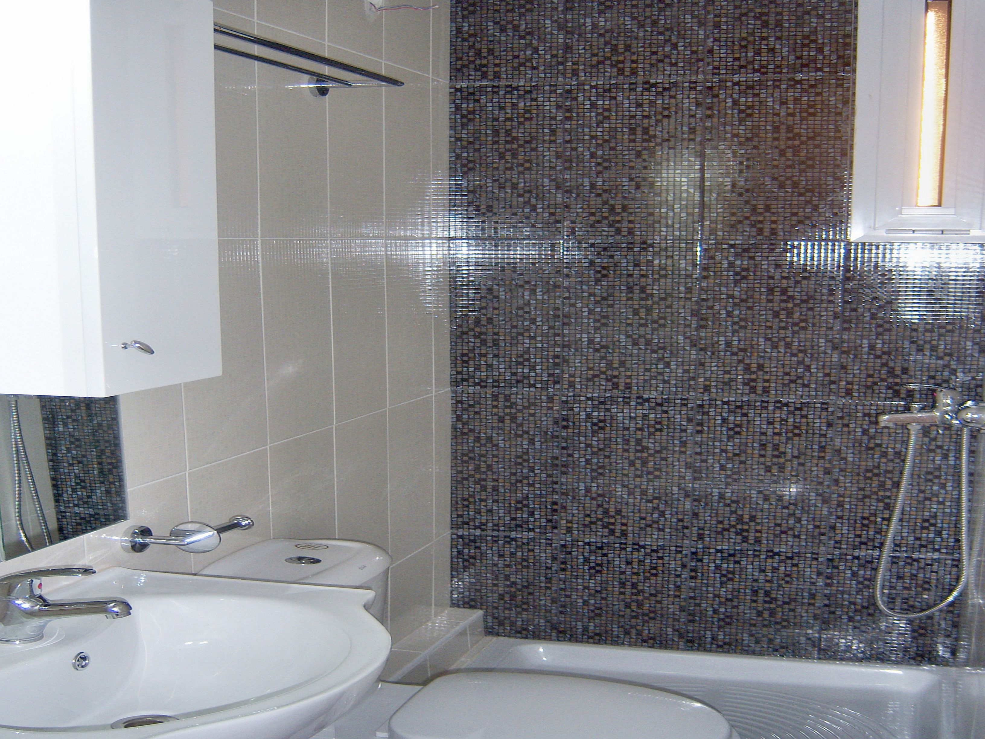 A bathroom with a white sink, a toilet, and a shower area.