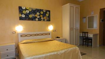 Una camera da letto con un letto, comodini, una scrivania, una sedia, un armadio e un quadro appeso al muro.