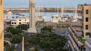 A marina with boats, a monument, and surrounding buildings. - Boutique Océano - Adults Only (Santa Cruz de Tenerife)