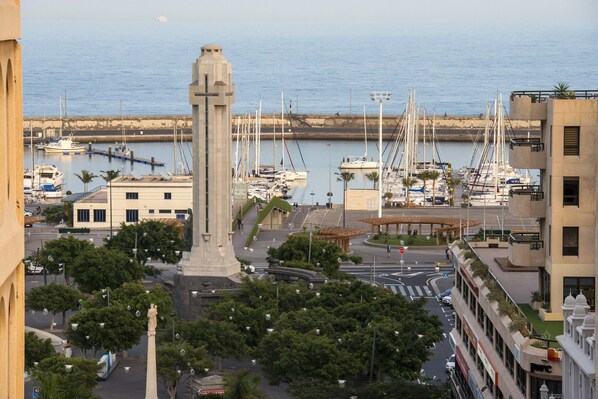Una marina con barcos, un monumento y edificios circundantes.