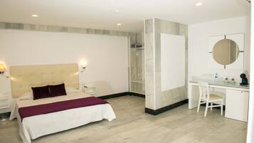 A modern hotel room with a bed, desk, chair, and a large mirror.