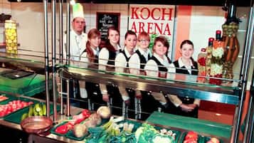 A buffet area with various food items and a sign reading "KOCH ARENA".