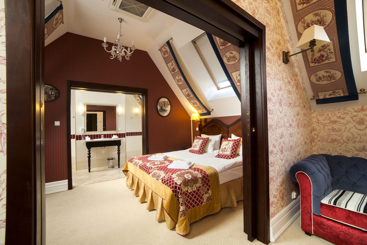 Un dormitorio con una cama grande, un tocador y un sofá rojo.