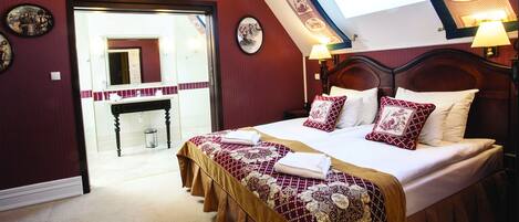 A bedroom with a large bed, a wooden headboard, and a skylight.