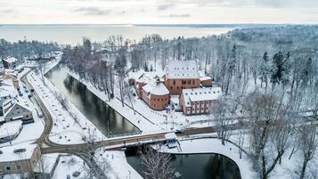 Escena invernal con un río, edificios y árboles cubiertos de nieve.