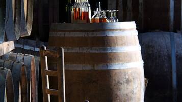Wooden barrels stacked in a dimly lit room with a chair in the foreground.
