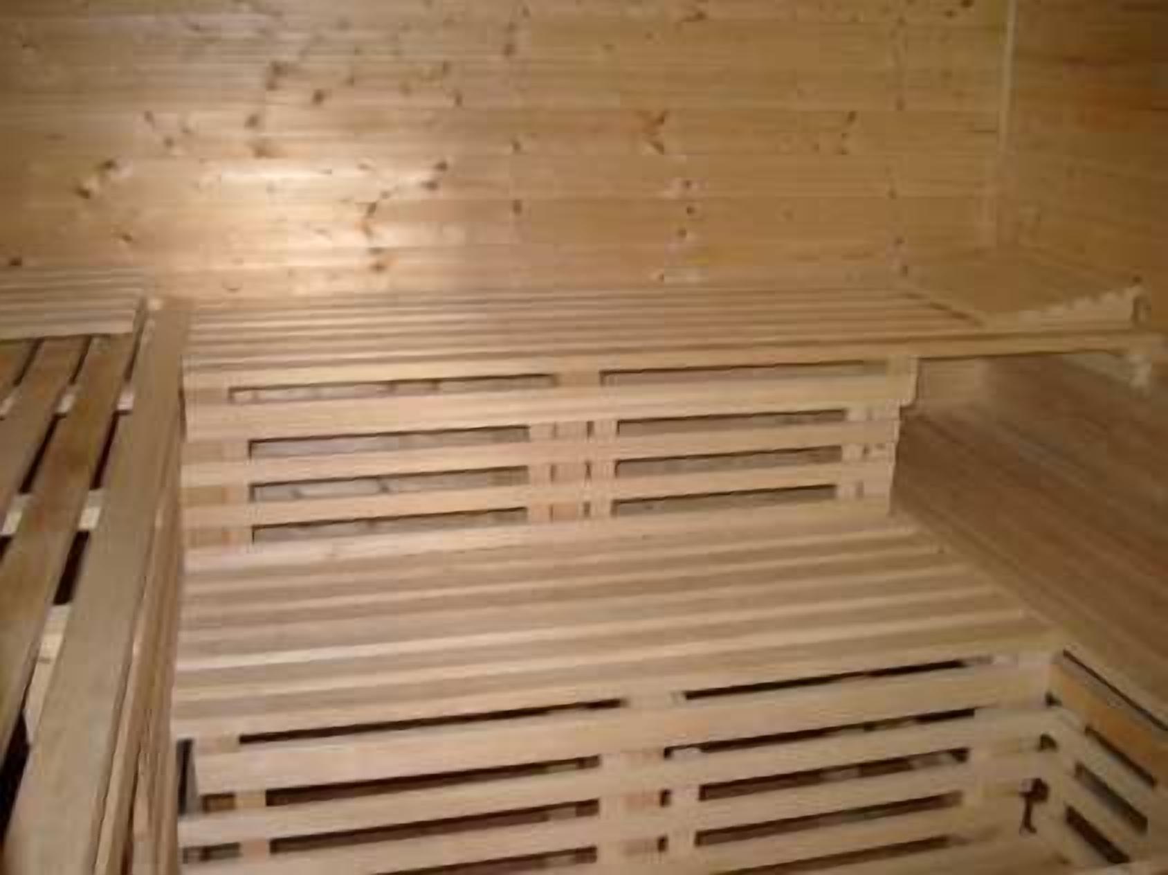 A room with wooden slatted benches and a wooden wall.