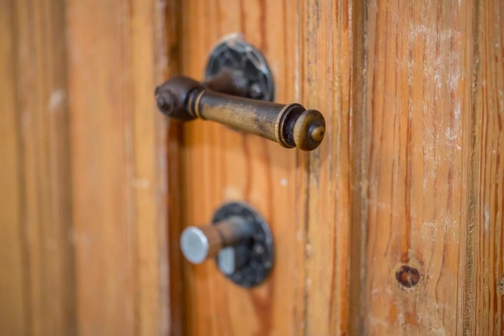 A wooden door with a brass door handle and a round keyhole.