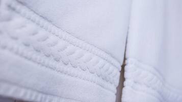 Primer plano de un tejido blanco con un patrón texturizado, probablemente parte de una prenda o tapicería.