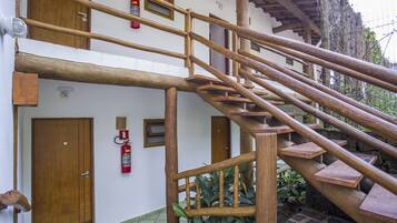 Una escalera de madera con un extintor fijado en la pared.