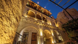 A historic building with arched doorways and a balcony. - Roma Cave Suite Hotel (Nevsehir)