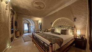 Un dormitorio con una cama grande, un cabecero de madera, una mesita de noche y un espejo.