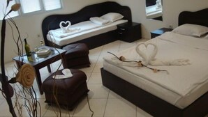Quarto com cama, mesa de cabeceira, cômoda e janela com persianas.