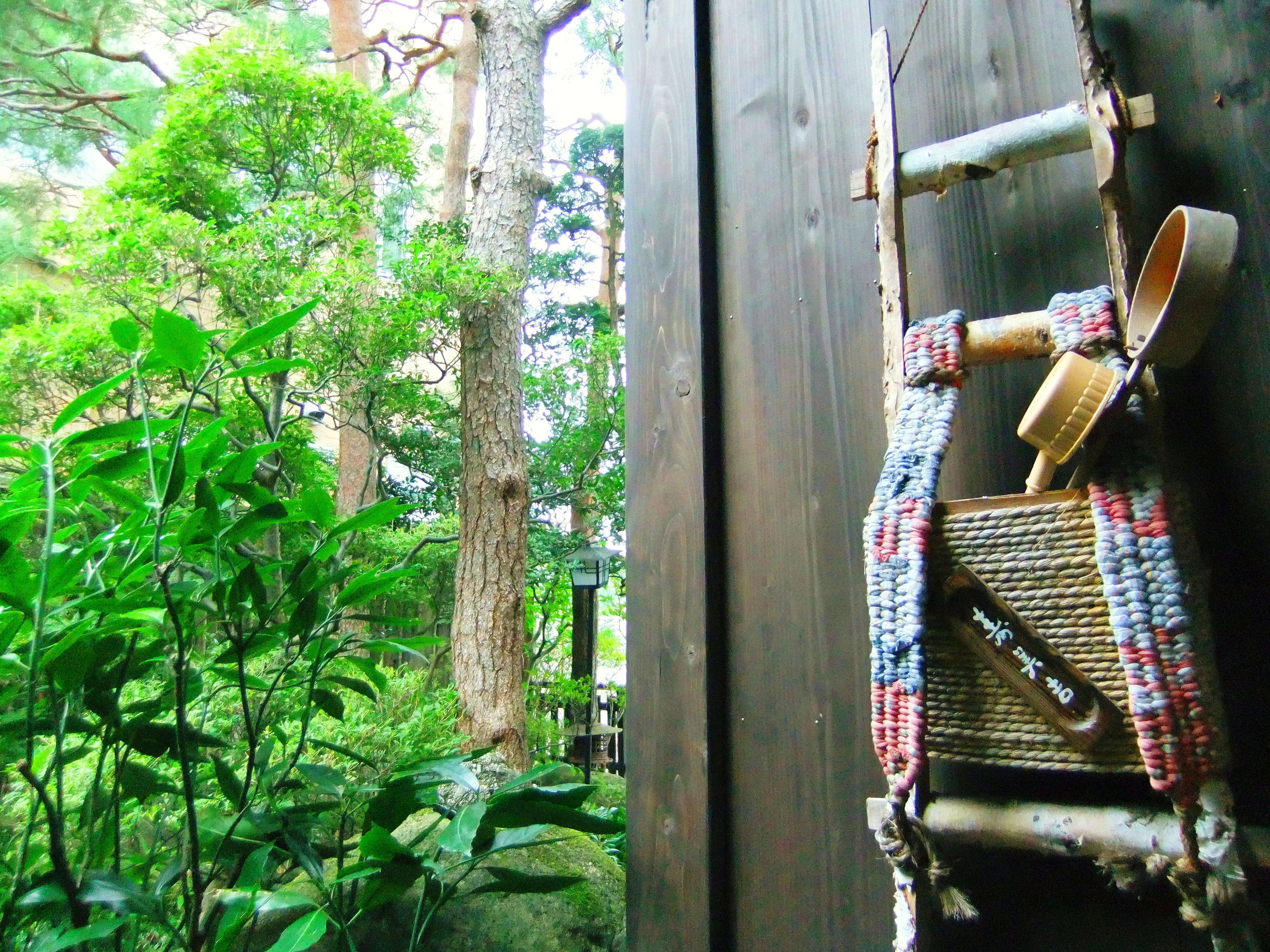 A rustic wooden structure with a woven mat and a traditional woven basket hanging on a wooden beam.
