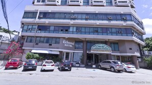 A multi-story hotel with a prominent 'Richmond Hotel' sign, several parked cars, and a 'Joe's Mambo Bldg' sign. - Richmond Plaza Hotel (Cebu City)