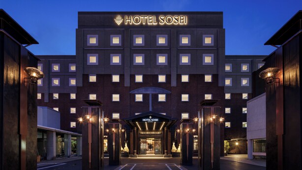 A modern hotel entrance with a prominent sign, a covered walkway, and uniform windows. - Hotel Sosei Sapporo - MGallery Collection (Sapporo)