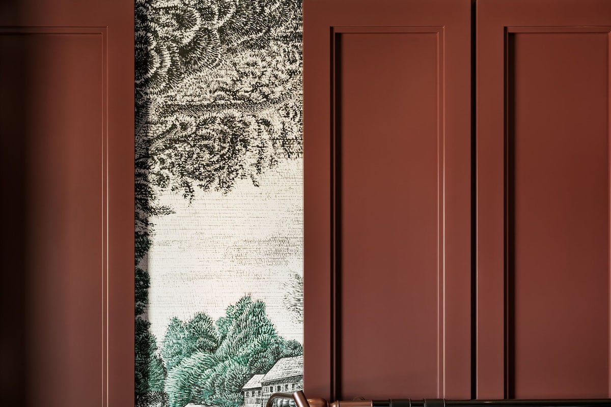 A hotel room with a bed, a nightstand, and a wall tapestry.