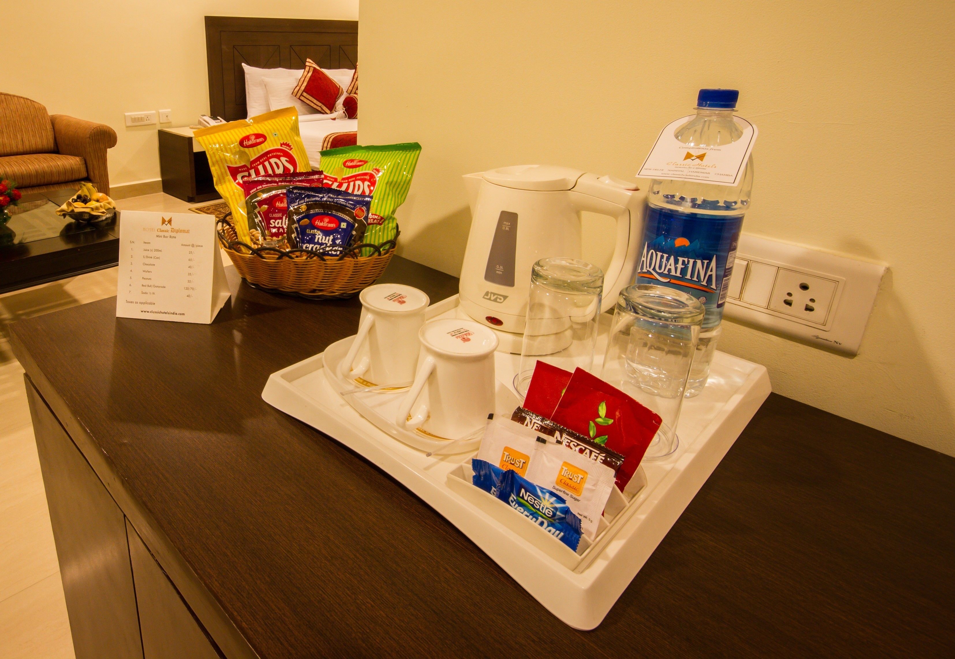 A hotel room's breakfast tray with snacks, coffee, water, and tea.