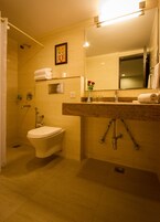 Een badkamer met toilet, douche, wastafel en spiegel.