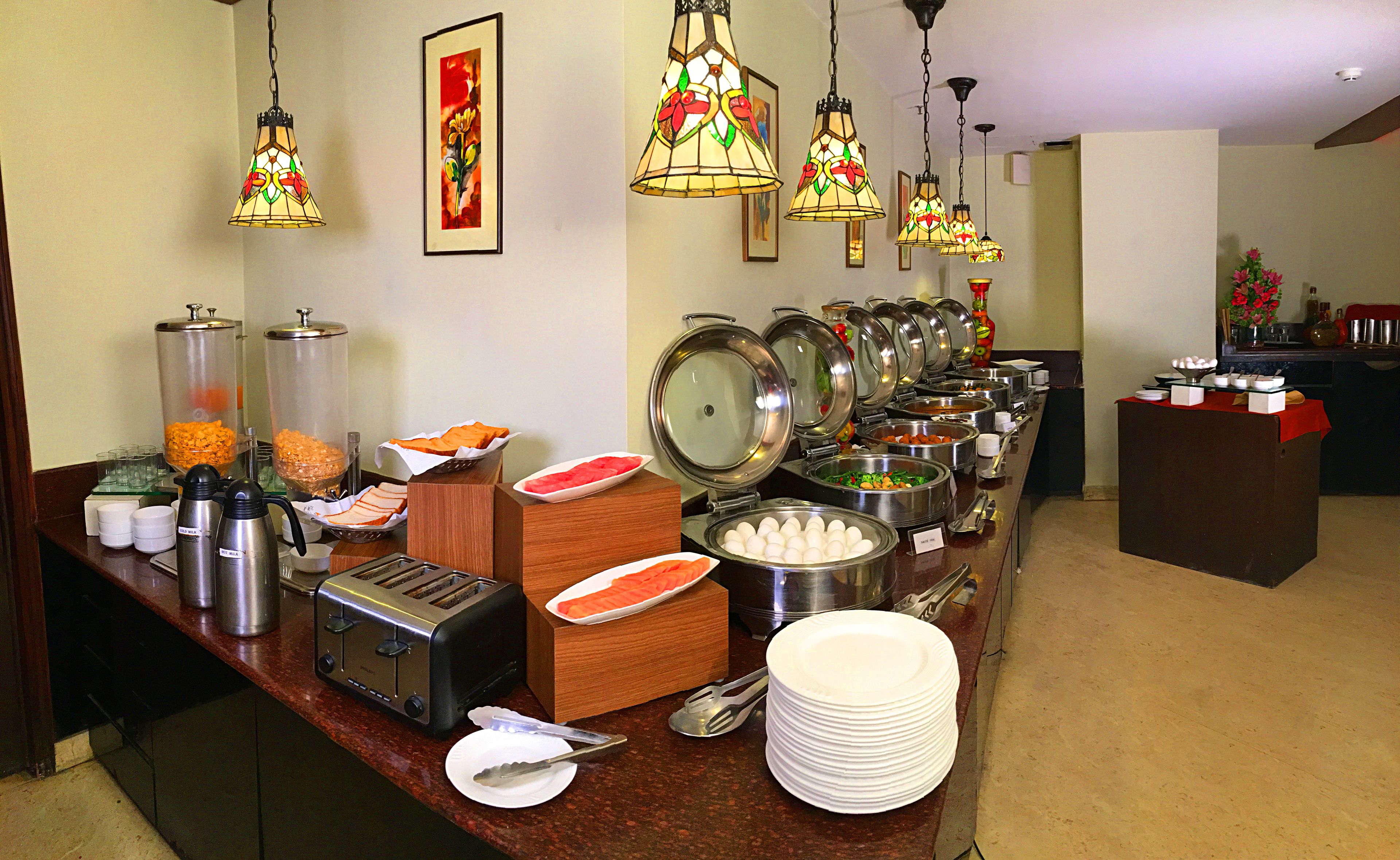 A buffet setup with various food items and utensils.