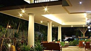 An outdoor patio area with a modern design, featuring a seating area with benches and tables, surrounded by potted plants and a patterned stone pathway. - Smile Hua-Hin Resort (Hua Hin)