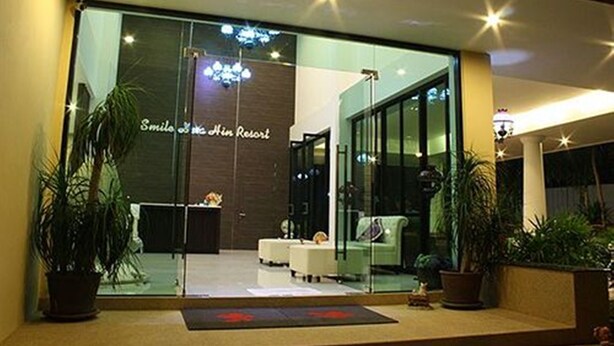 A modern hotel lobby with a reception desk, seating area, and potted plants. - Smile Hua-Hin Resort (Hua Hin)