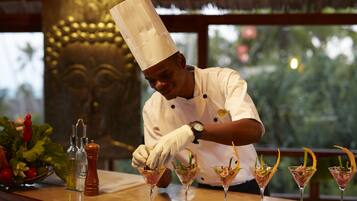 A chef preparing drinks at a bar with a decorative background.