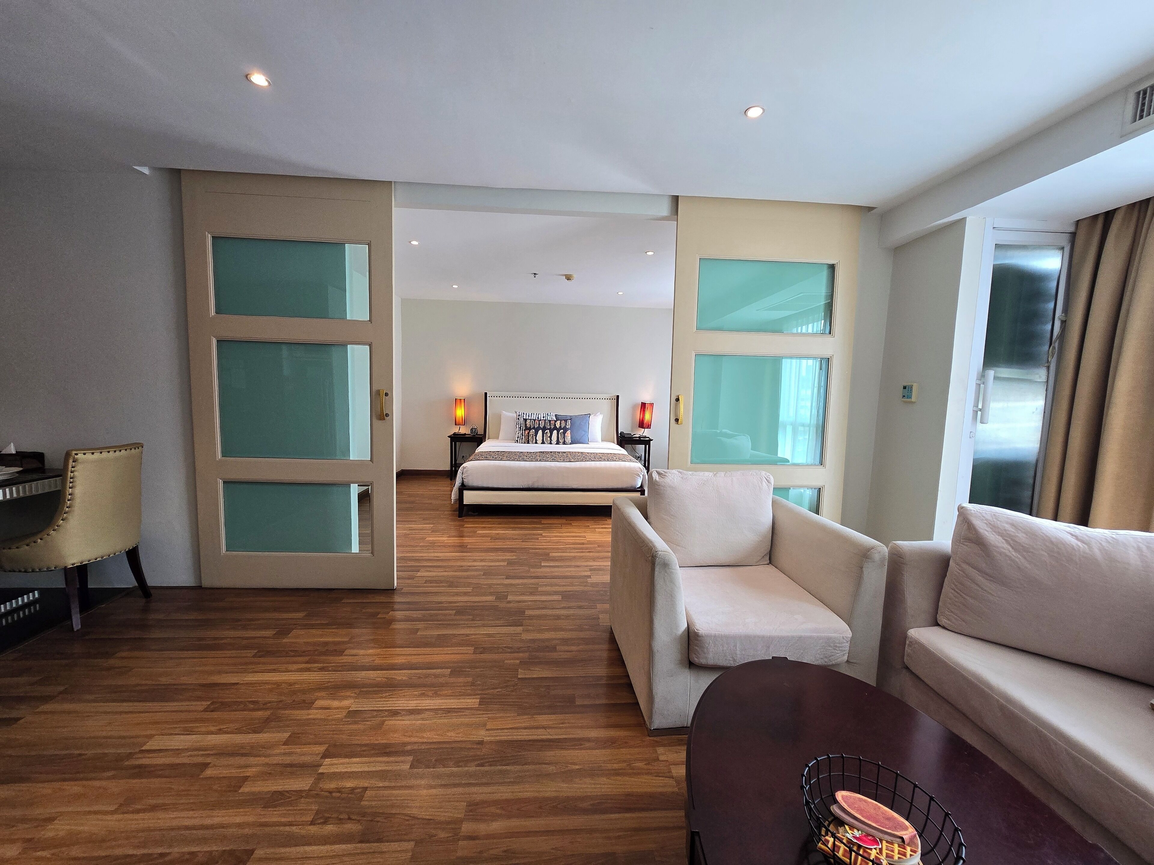 Ein Hotelzimmer mit einem großen Bett, zwei Sesseln, einem kleinen Tisch und einem Sofa.