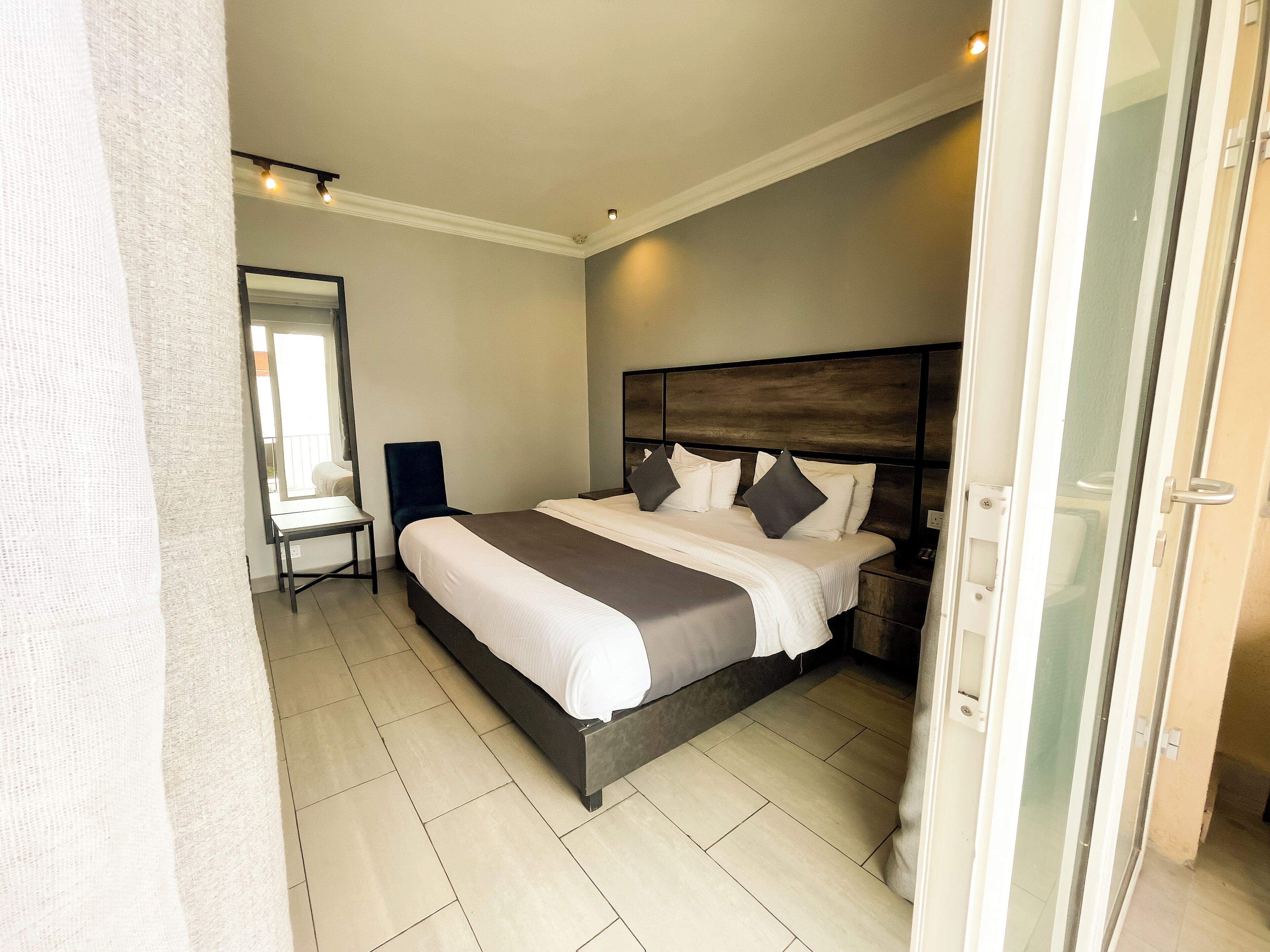 Een moderne hotelkamer met een groot bed, een nachtkastje en een stoel.