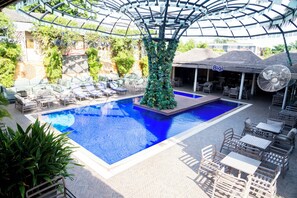 Relax by the pool surrounded by lush greenery and comfortable seating areas.