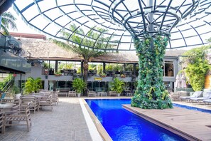 Relax by the pool surrounded by lush greenery and modern architecture.
